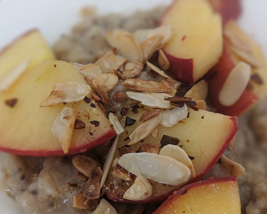 Oatmeal topped with fresh apple slices and flaked almonds