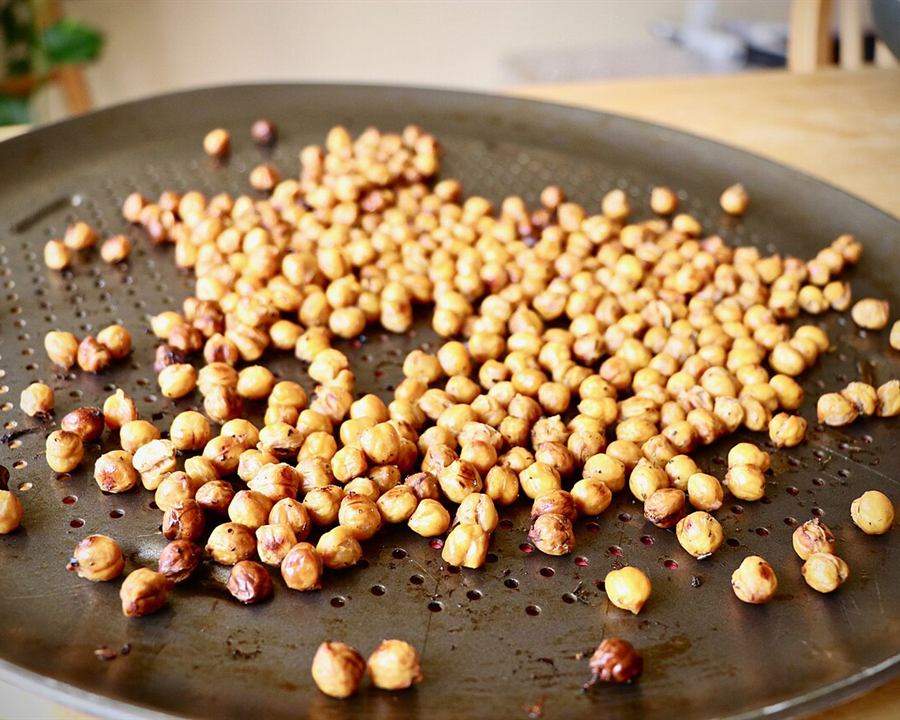 Roasted chickpeas spread on a baking tray
