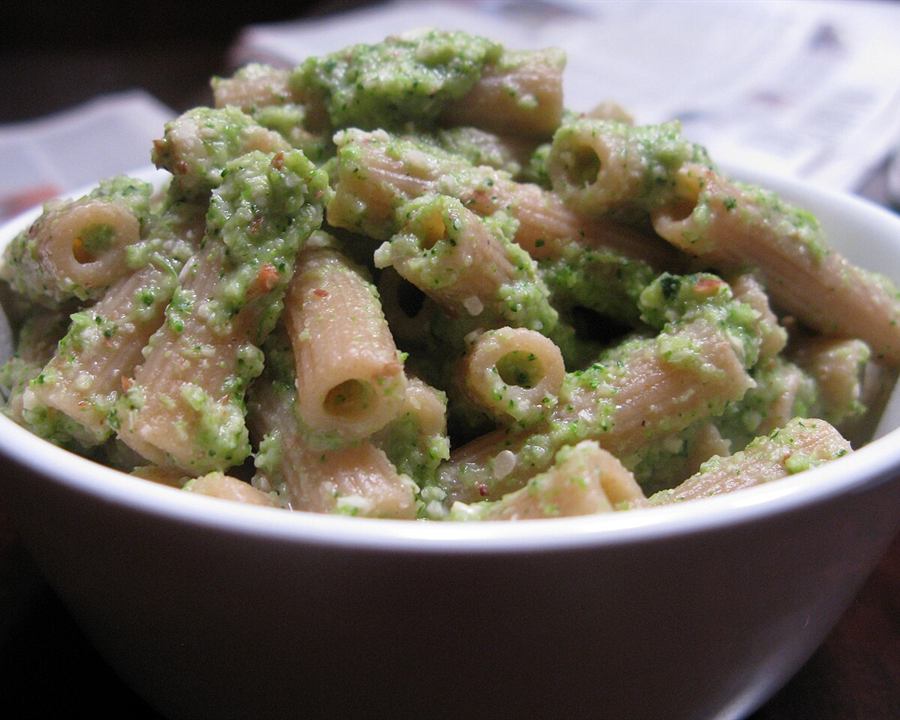 Whole-wheat pasta tossed with a green broccoli sauce in a white bowl