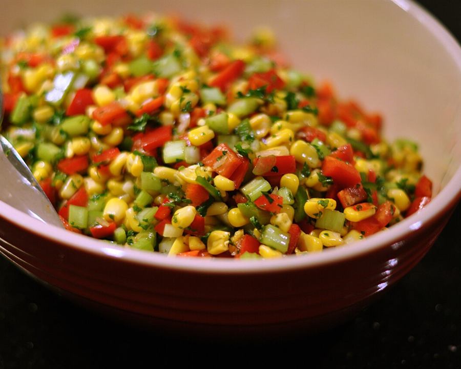 A bowl of sweetcorn salad with red and green pepper, celery and chilli