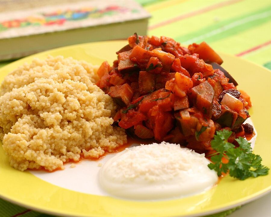 Couscous served with aubergine (eggplant) chutney and a spoon of yogurt