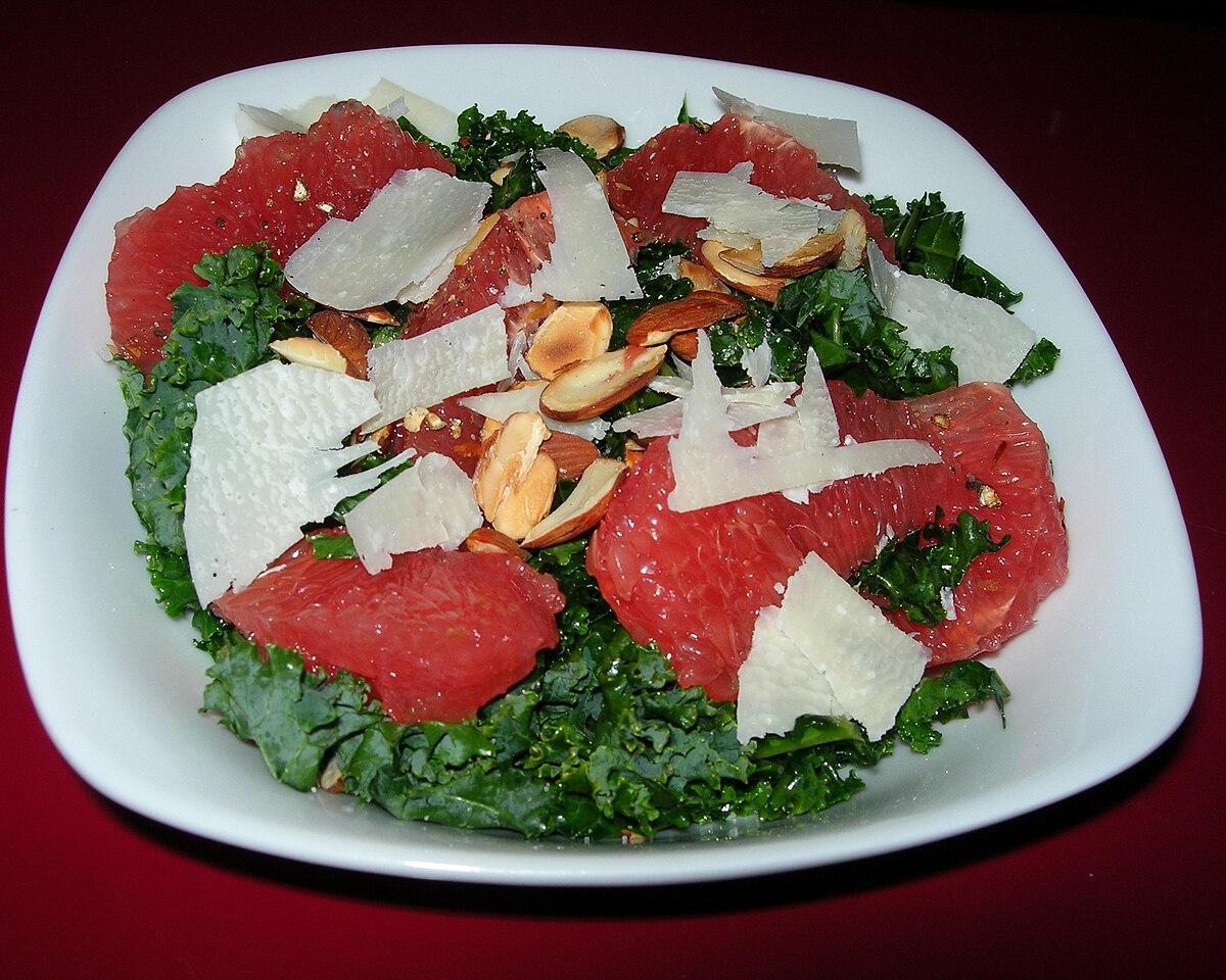 A kale salad with grapefruit segments, shaved hard cheese and toasted almonds