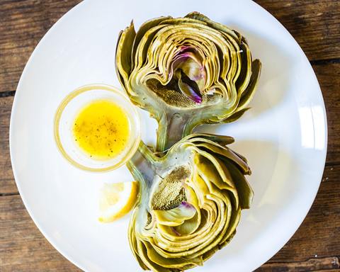 Serving inspiration: A steamed artichoke on a white plate with a small dish of butter and lemon. Not verified as this exact recipe.