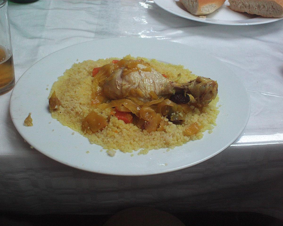Chicken served on couscous on a white plate