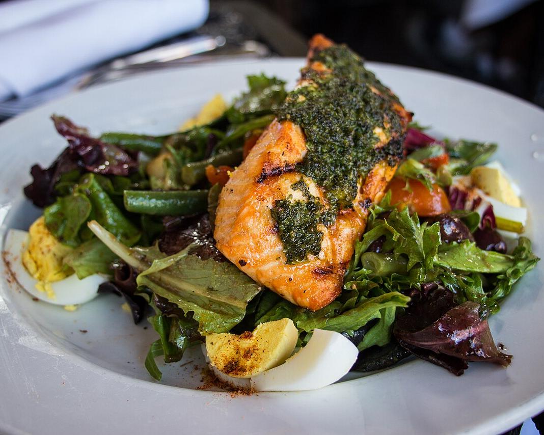 A grilled salmon niçoise salad with green beans, egg, potatoes and tomatoes