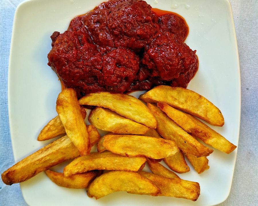 Meatballs in tomato sauce served with potato wedges