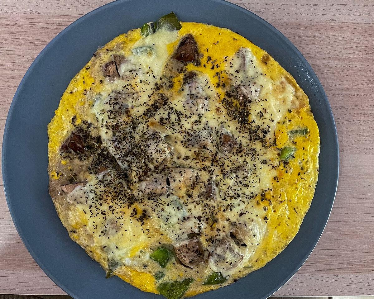 An omelette with mushrooms, peppers and cheese on a blue plate