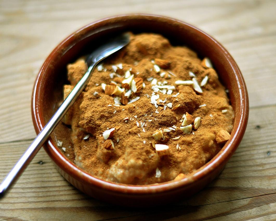 Oatmeal with apples, cinnamon and almonds in a brown bowl