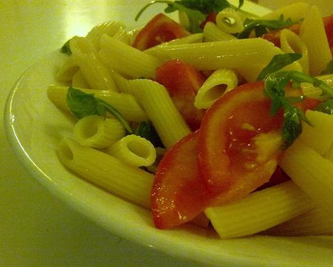 Serving inspiration: Penne with fresh tomato and rocket (arugula) on a green plate. Not verified as this exact recipe.