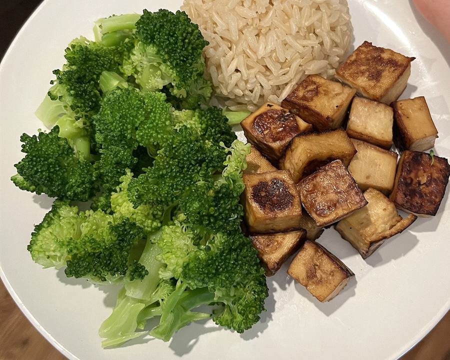 Baked tofu cubes with steamed broccoli and brown rice on a plate