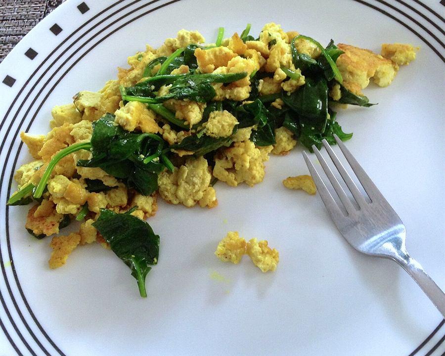 Tofu scramble with spinach on a white plate